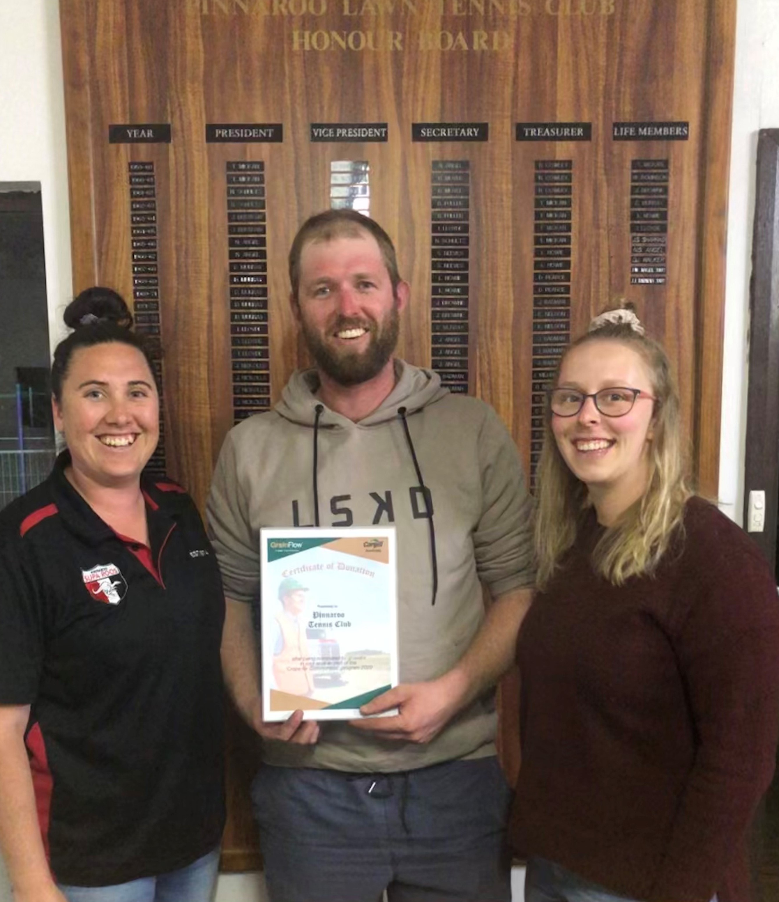 Joel (President), Steph (treasurer) and Georgia (committee member) Heinicke, in front of the life members board at the Pinnaroo Tennis Club